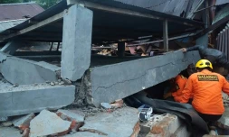 Les secours indonésiens fouillent les décombres d'un bâtiment effondré à Mamuju, sur l'île des Célèbes, frappée par un puissant séisme le 15 janvier 2021