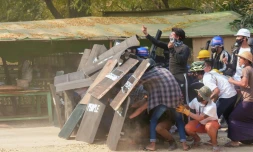 Des manifestants à couvert derrière des boucliers lors de heurts avec la police, le 7 mars 2021 à Nyaung-U, en Birmanie