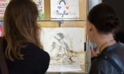 Des visiteurs regardent des dessins et des cartes réalisés aprÚs les attentats de Paris collectés par les Archives de Paris, à Paris le 17 septembre 2016