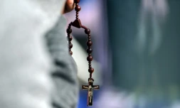 Un homme prie le 27 septembre 2015 à Philadelphie, en Pennsylvanie, en attendant l'arrivée du pape venant célébrer une messe en plein air 