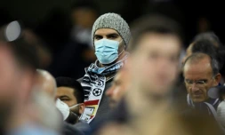 Un amateur de football, le visage couvert d'un masque de protection contre le coronavirus, assiste au match de l'Olympique lyonnais contre la Juventus Turin en huitième de finale aller de Ligue des champions, à Lyon (France) le 26 février 2020
