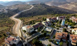 Vue aérienne de la maison du Palestinien Saadat Gharib (c), encerclée par les logements de colons israéliens, le 19 juillet 2022 à Beit Ijza, en Cisjordanie occupée