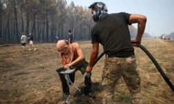 Un volontaire remplit un seau d’eau pour aider à lutter contre l’incendie dans une forêt à Lanton, à l’ouest de Bordeaux, le 29 juillet 2026, lors des feux de forêt dans le département de la Gironde, dans le sud-ouest de la France