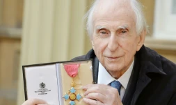 L'auteur britannique Michael Bond, qui a écrit la série de livres de Paddington Bear, pose avec sa médaille d'Officier de l'Ordre de l'Empire britannique au palais de Buckingham à Londres, le 27 octobre 2015