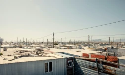 Vue générale du site de Blikkiesdorp, fait de rangées de cahutes sur un terrain désolé et situé à 25 km du centre-ville du Cap, le 19 août 2024, en Afrique du Sud. En 2010, la municipalité a été accusée d'y avoir déplacé des milliers de sans-abris à l'approche de la Coupe du monde de football organisée par ce pays