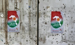 Des affiches encourageants les citoyens à voter au référendum sur l'indépendance du Kurdistan, collées sur un mur criblé de balles à Kirkouk, le 24 septembre 2017