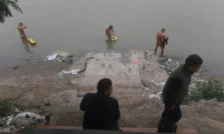 Des adeptes du naturisme se baignent dans le fleuve Rouge sous le regard de passants, le 11 décembre 2017 à Hanoï, au Vietnam