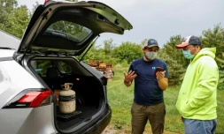 Chad Dorger (gauche), de l'entreprise Tradewater Refrigerant Solutions, achète une bonbonne de gaz nocif pour l'environnement à Rick Karas (droite), à Peotone dans l'Illinois le 11 août 2021