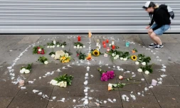 Une femme dispose une bougie à proximité du lieu de l'agression mortelle d'un homme à Hambourg, le 29 juillet 2017