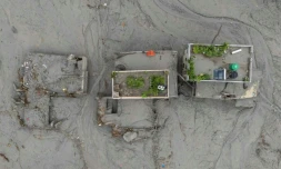 Vue aérienne de maisons recouvertes de boue aprÚs la crue destructrice qui a fait plus de 600 morts à la frontiÚre entre le Népal et la Chine, le 29 août 2026 à Devighat, dans le district népalais de Nuwakot