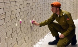 Un soldat israélien place une fleur sur les noms des soldats tués au service de leur pays ou dans des attentats, à Jérusalem, à l'occasion du Jour du Souvenir, le 18 avril 2018