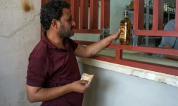 Un Irakien achète une bouteille de whisky dans une échoppe, le 10 mai 2017 à Mossoul