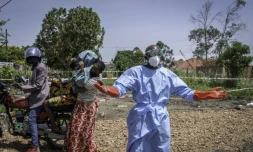Dieudonné Sezabo, un agent de santé, demande de l'aide pour accueillir une jeune femme soupçonnée d'avoir la maladie Ebola, à l'hôpital de Rwampara, dans le nord-est de la République démocratique du Congo (RDC) le 26 mai 2026

