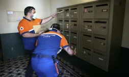 Des membres de la Protection civile distribuent des masques dans les boites Ă lettres d'habitants d'Ajaccio, en Corse, le 7 mai 2020