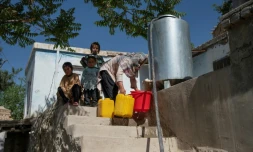 Une habitante récupère de l'eau potable à partir d'une citerne à Kaboul, le 27 avril 2025 en Afghanistan