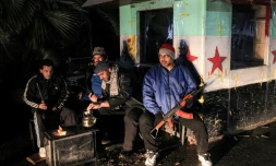 Des habitants de Damas sur un poste de contrôle du quartier de Chaghour, le 29 décembre 2024