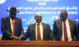 Le président soudanais Omar el-Béchir (C) tient les mains du président sud-soudanais Salva Kiir (G) et du chef rebelle Riek Machar (D) après la signature à Khartoum d'un accord de cessez-le-feu, le 27 juin 2018