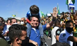 Le président brésilien Jair Bolsonaro porte le fils d'un de ses partisans lors d'un rassemblement à Brasilia le 31 mai 2020