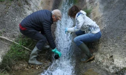 Des bénévoles prélèvent des échantillons d'eau des rejets de l'usine Solvay, qui fabrique des molécules PFAS, à Salindres, dans le Gard, le 18 avril 2024