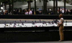 Une personne place un drapeau américain sur le mémorial pour les victimes du 11-Septembre à New York, le 11 septembre 2022
