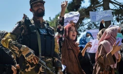 Des Afghanes manifestent contre l'ingérence du Pakistan, sous l'oeil d'un combattant taliban, à Kaboul le 7 septembre 2021