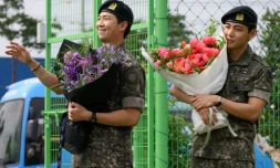 Les membres du boys band K-pop BTS, RM (L) et V à Chuncheon, en Corée du Sud, le 10 juin 2025, après leur libération du service militaire