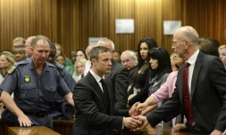 Oscar Pistorius serre la main de son oncle Arnold Pistorius avant d'ĂȘtre emmenĂ© en prison Ă l'issue de son procĂšs le 21 octobre 2014 Ă Pretoria