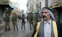 Un palestinien face à des membres des forces de sécurité israéliennes, le 27 octobre 2015 à Hébron, en Cisjordanie occupée