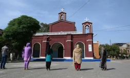 Des fidèles chrétiens prient à l'extérieur, devant une église à Lahore, le 10 avril 2020 au Pakistan