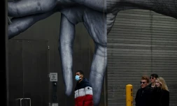 Un homme marche devant une fresque murale à New York, le 14 mars 2020