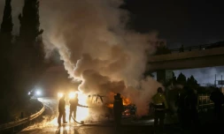 Des pompiers éteignent un véhicule de la Finul, incendié par des manifestants, sur la route menant à l'aéroport de Beyrouth, le 14 février 2025 au Liban