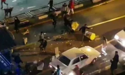 Image extraite d'une vidéo fournie par l'agence iranienne Mehr News montrant un groupe d'hommes tapant dans des plots de circulation dans une rue de Téhéran le 30 décembre 2017