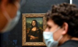 Un visiteur portant un masque devant le tableau de La Joconde, au Louvre, le 19 mai 2021 Ă Paris