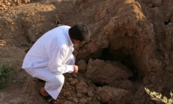 Un Irakien examine le site où sont enterrés des jihadistes de l'EI à Dhoulouïya, à 90 km au nord de Bagdad, le 10 octobre 2017