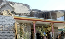 Des Afghans se rassemblent devant une maison endommagée par une frappe pakistanaise à Asadabad dans l'est de l'Afghanistan le 25 novembre 2025