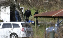 Des gendarmes et des experts en médecine légale fouillent une cabane de jardin le long d'une route près de Domessin dans l'est de la Savoie le 14 février 2018