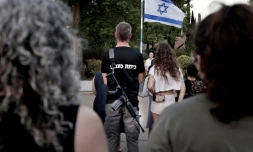 Les habitants du kibboutz israélien de Sha'ar Hagolan, prÚs de la Jordanie, assistent à une cérémonie du drapeau pour rendre hommage, le 12 octobre 2023, aux Israéliens tués lors de l'attaque du Hamas le 7 octobre 2023