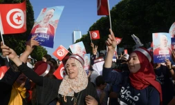 Des partisans du candidat à l'élection présidentielle tunisienne du mouvement islamiste Ennahdha Abdelfattah Mourou (portrait) font campagne le long de l'avenue Habib Bourguiba, dans le centre de Tunis, le 13 septembre 2019