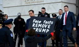 Une manifestante en faveur de la destitution de Donald Trump tient une pancarte Ă la sortie du lieutenant-colonel Alexander Vindman, tĂ©moin dans l'enquĂȘte visant le prĂ©sident amĂ©ricain, le 19 novembre 2019