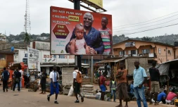 Des habitants de Freetown en Sierra Leone marchent sous une affiche de campagne contre Ebola représentant le président Ernest Bai Koroma