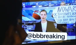 Une femme apparaßt derriÚre une présentatrice pendant le journal télévisé de la plus importante chaßne de Russie avec une pancarte sur laquelle est écrit "Non à la guerre. Ne croyez pas la propagande. On vous ment, ici", le 14 mars 2022