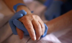 Un personnel soignant tient la main d'un patient en soins palliatifs, à l'hôpital Eugénie d'Ajaccio, le 23 avril 2020