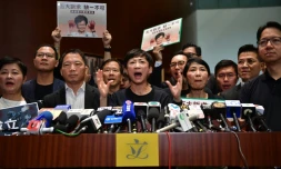 Une parlementaire pro-démocratie de Hong Kong, Tanya Chan (C), s'adresse aux médias après l'interruption du discours de politique générale de la cheffe de l'exécutif Carrie Lam, caricaturée les mains ensanglantées sur des affiches, le 16 octobre 2019