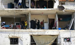 Des familles palestiniennes retournent dans leurs maisons gravement endommagées dans un immeuble touché lors d'un précédent bombardement israélien, dans la ville de Khan Younés, dans le sud de la bande de Gaza, le 30 juin 2024