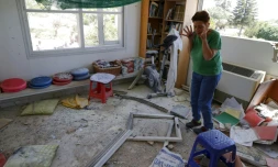 Une femme au milieu des dégùts provoqués par l'explosion d'une roquette tirée de la bande de Gaza et qui s'est abattue sur le village de Netiv Haasara en Israël, le 4 mai 2019
