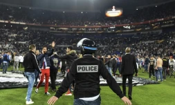 Des supporters lyonnais du Virage Sud envahissent la pelouse pour échapper à des jets de projectiles de supporters turcs, le 13 avril 2017 au Parc OL