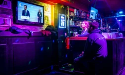 Des clients et salariés d'un bar regardent la retransmission de la conférence de presse du Premier ministre néerlandais Mark Rutte annonçant de nouvelles restrictions sanitaires, le 12 novembre 2021 à Eindhoven