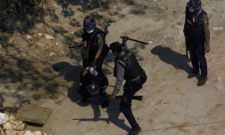 Des policiers frappent un protestataire lors d'une manifestation pro-démocratie à Rangoun, le 6 mars 2021