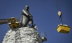 Des employés municipaux disposent des sacs de sable autour d'un momument pour le protéger des bombardements russes, le 26 mars 2022 à Kharkiv (est de l'Ukraine)
