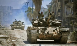 Des combattants gouvernementaux progressent en direction de positions du groupe jihadiste Etat islamique (EI) dans le quartier de Hajar al-Aswad dans le sud de Damas. Photo fournie par l'agence officielle syrienne SANA, le 14 mai 2018